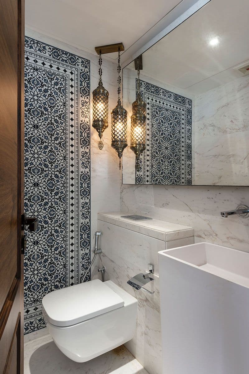 a white toilet sitting in a bathroom next to a bath tub and sink under two lights, classique, tadelakt