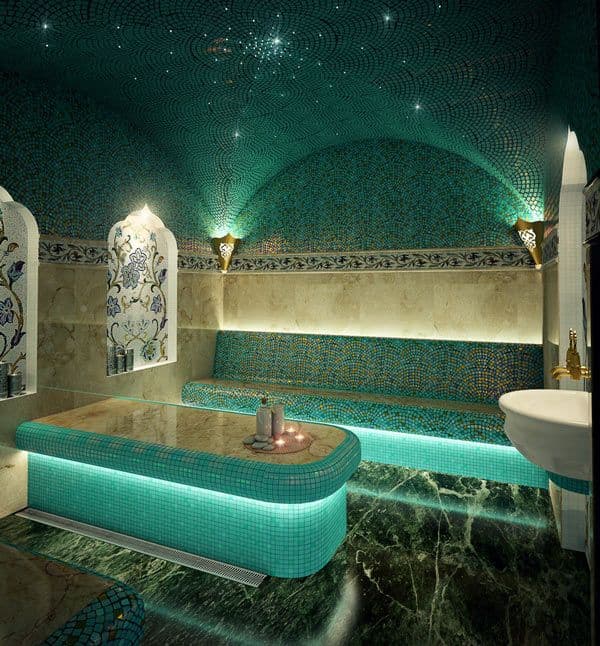 a fancy bathroom with blue and green tiles on the walls, lights above the bathtub, classique, zellige
