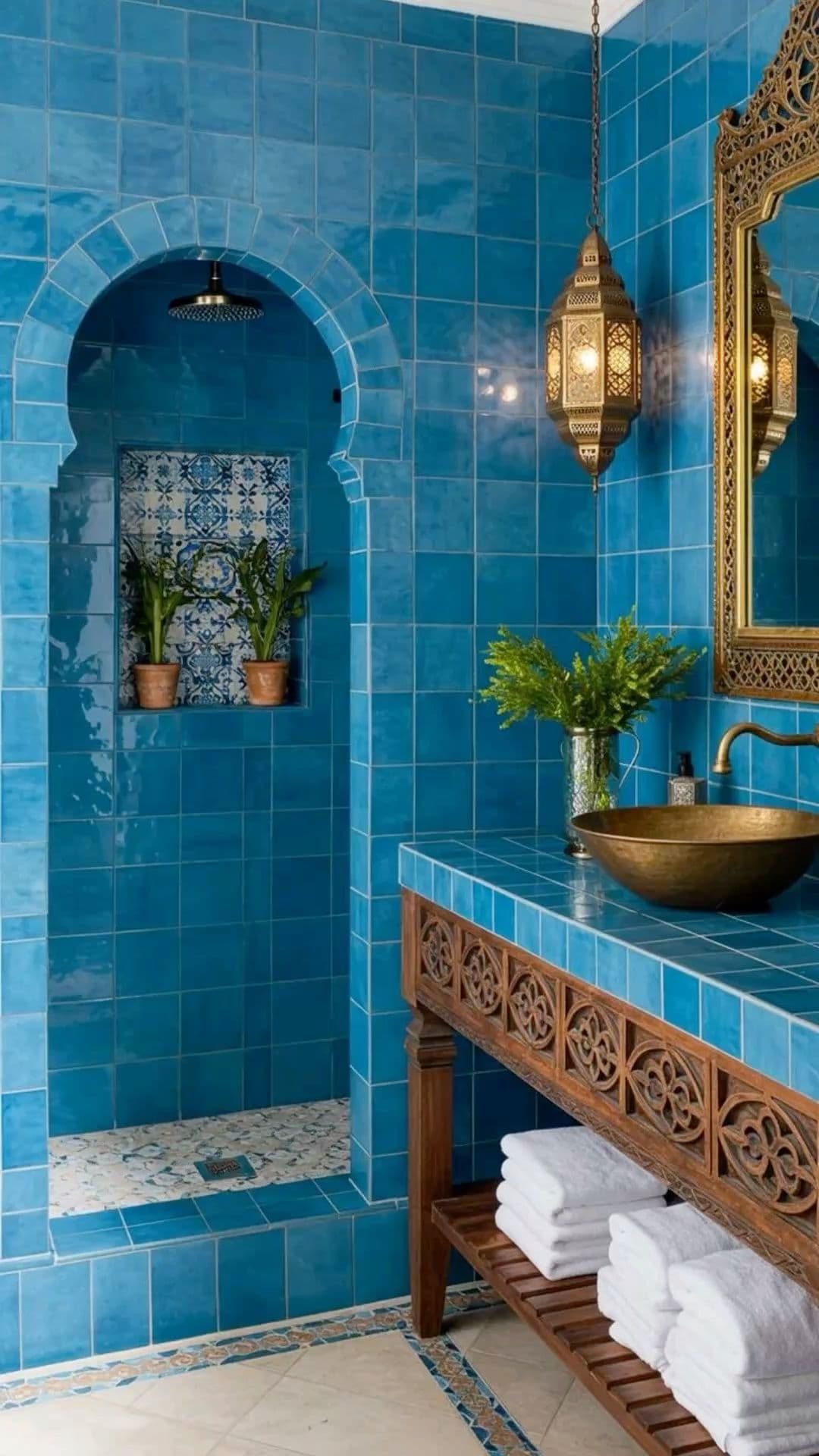 a bathroom with blue tiles and gold fixtures, classique, zellige